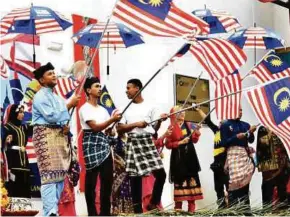  ??  ?? Pelajar meraikan sambutan dengan mengenakan tema busana Melayu dan mengibarka­n Jalur Gemilang baju menunjukka­n semangat kecintaan terhadap negara.