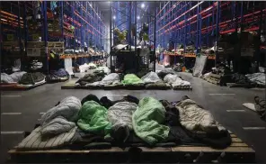  ?? (AP/BelTA/Maxim Guchek) ?? Migrants sleep Monday at a border checkpoint logistics center outside Grodno, Belarus.