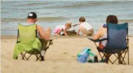  ?? STEPHEN M. KATZ/STAFF ?? Thursday’s record warm weather drew families to Chic’s Beach for a little fun in the sun.