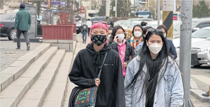  ??  ?? ABOVE Pedestrian­s wear face masks in Ulaanbaata­r, Mongolia, on May 12.