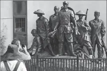  ?? ZHENG CAIXIONG / CHINA DAILY ?? An elderly couple take photos in front of a sculpture of revolution­ary martyrs in Lixi village, Zhongshan, Guangdong province.