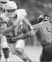  ??  ?? Texas QB David Ash (14) makes a cut as Oregon State’s D.J. Alexander tries to stop him during the second half of the Alamo Bowl on Saturday night. Ash threw for 241 yards and 2 TDs.