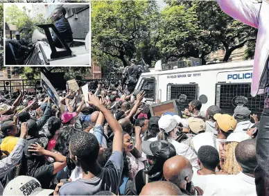  ?? Picture: Alaister Russell ?? Police officers work to clear supporters outside the Specialise­d Commercial Crimes Court in Pretoria where self-proclaimed prophet Shepherd Bushiri, inset, and his wife were granted bail on fraud and money-laundering changes.