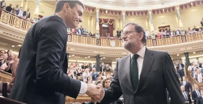  ?? Foto: dpa ?? Wenn Gesichter Bände sprechen: Der abgewählte Regierungs­chef Mariano Rajoy gratuliert seinem Nachfolger Pedro Sánchez.