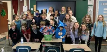  ?? Courtesy of Kelsey O’Leary ?? Kelsey O’Leary’s fourth grade class at Baker Elementary poses with the prize basket the students earned for collecting the most money for the school’s coin drive.