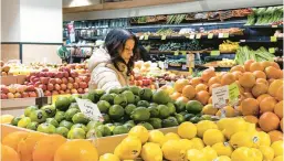  ?? PETER K. AFRIYIE/AP ?? A woman browses produce Jan. 19 in New York. In final rule changes announced this week, a federal program will offer a wider choice of foods from different cultures.