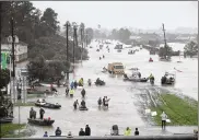  ?? JOE RAEDLE / GETTY ?? People walk down a flooded street as they evacuate their homes after the area was inundated with flooding from Hurricane Harvey in Houston. Relentless rain continued Monday for the fourth consecutiv­e day, paralyzing Houston, the nation’s fourth-largest...