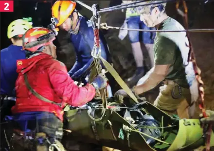  ??  ?? Delicate work: A group of rescuers help guide one of the boys through a tunnel in the cave system 2