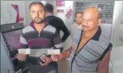  ?? HT PHOTO ?? Two customers displaying the fake bank notes dispensed from the ▪
ATM.