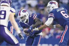  ?? Brett Carlsen / Getty Images ?? Tyree Jackson hands off the ball to Christian Wade during the second quarter of the Bills’ 27-23 win over the Vikings.