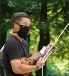  ?? Edward DeArmitt/Pittsburgh Symphony Orchestra ?? Pittsburgh Symphony Orchestra violinist Christophe­r Wu joins other performers to record a socially distanced program outside at Hartwood Acres in June.