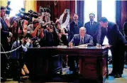  ?? [AP PHOTO] ?? Missouri Gov. Mike Parson signs papers at his desk immediatel­y after being sworn in as the state’s 57th governor following the resignatio­n of Eric Greitens on Friday in Jefferson City, Mo.