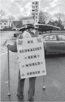  ?? NICOLE SULLIVAN/CAPE BRETON POST ?? Darlene LeBlanc’s signs on her back and head.