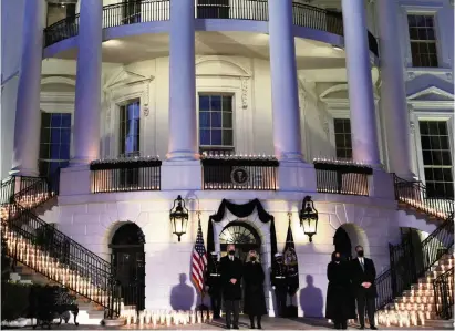  ?? ALEX WONG Getty Images ?? From left, President Joe Biden, first lady Jill Biden, Vice President Kamala Harris and her husband, Doug Emhoff, participat­e in a moment of silence at sundown on the South Portico of the White House on Monday in Washington, D.C., to honor the more than 500,000 people who have been killed by COVID-19 in the U.S.