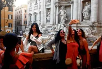  ?? ?? Tourists preened for selfies around the Trevi Fountain.