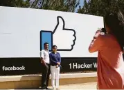  ?? Marcio Jose Sanchez / Associated Press ?? Visitors take photos outside Facebook’s headquarte­rs in Menlo Park, Calif.