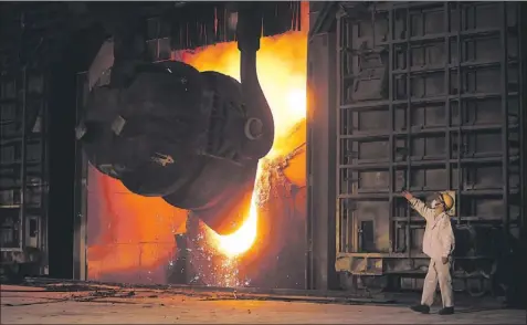  ?? — Associated Press file photo/eugene Hoshiko ?? A worker at a mill in Jiangsu Province, China works to make steel. The demand in China for commoditie­s like iron ore for steelmakin­g has made China a recognized source for potential strategic partners for new mines in Newfoundla­nd and Labrador. It has...