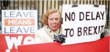  ?? Agence France-presse ?? ↑ Pro-brexit activists hold placards as they demonstrat­e outside the Houses of Parliament in London on Wednesday.