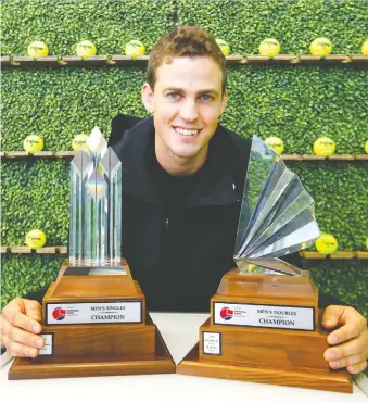  ?? DARREN MAKOWICHUK ?? Vasek Pospisil shows no superstiti­on Tuesday at the Alberta Tennis Centre, by touching championsh­ip trophies that will be handed out during the 2020 Calgary National Bank Challenger.