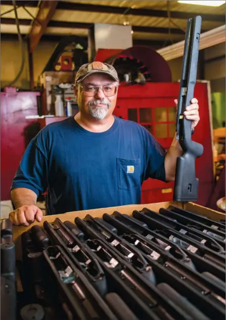  ?? RUSTY HUBBARD/THREE RIVERS EDITION ?? Fred Choate, president of Choate Machine and Tool in Bald Knob, holds one of the synthetic gun stocks the company makes.