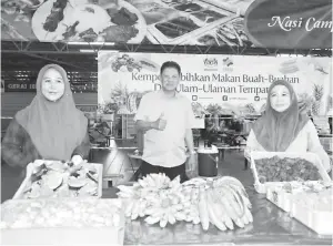  ??  ?? KEMPEN: Abdul Jaafar bersama warga kerja FAMA Sarawak mempromosi­kan Kempen Lebihkan Makan Buah-Buahan dan Ulam-Ulaman Tempatan di MNS.