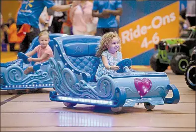  ?? NWA Democrat-Gazette/BEN GOFF ?? Two children try out motorized Disney Frozen sleighs during Wal-Mart’s Top Rated By Kids event in July in Rogers.