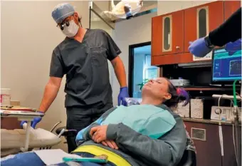  ?? AP PHOTO/GEORGE WALKER IV ?? Dentist Ryan O’Neill, left, repairs the teeth of Danielle Wilkes during a Sept. 7 clinic visit in Nashville.