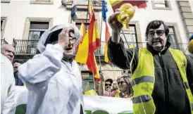  ?? CARLOS GIL ?? Sobre estas líneas, Ángel García Blanco vierte el contenido de un tarro de miel, y la protesta recorre la avenida de España de Cáceres. A la derecha marcha de camiones, también en Cáceres.