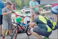  ?? Keith Bryant/The Weekly Vista ?? Steven Gonzalez, 9, left, helps his father, Mario Yarnell-Gonzales, decorate his bicycle with balloons and streamers for the bike parade.