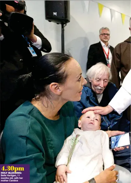  ??  ?? 4.30pm holy blessing: Bella Hartigan, 11 months old, with her mother Candice