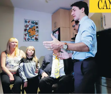  ?? JEFF MCINTOSH / THE CANADIAN PRESS ?? Prime Minister Justin Trudeau, right, speaks with Tracey Hume, left, and her granddaugh­ter Desiree Hume, 11, in their apartment in Calgary on Thursday, part of his trip to Alberta that included a roundtable with business leaders.