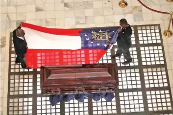  ?? AP PHOTOS/JOHN BAZEMORE ?? The Georgia state flag is prepared to lie on the casket of the Rev. C.T. Vivian in the Capitol rotunda during his memorial service Wednesday in Atlanta. Vivian, an early and key adviser to the Rev. Martin Luther King Jr. who organized pivotal civil rights campaigns and spent decades advocating for justice and equality, died Friday at 95.