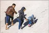  ?? Andres Leighton Associated Press ?? A MIGRANT family climbs the Rio Grande’s banks after crossing from Ciudad Juarez, Mexico, on Dec. 21.