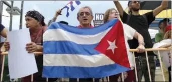  ?? LESLIE OVALLE/SOUTH FLORIDA SUN-SENTINEL VIA AP ?? Nelson Avila, center, joins anti-President Donald Trump protesters, calling for open relations with Cuba on Friday, in Miami. Trump thrust the U.S. and Cuba back on a path toward open hostility Friday with a blistering denunciati­on of the island’s...