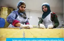  ?? — AFP photos ?? Syrians work at a factory making traditiona­l Syrian delicacies that is owned by Syrian refugee Mazen Obeido.