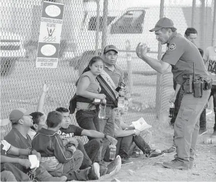  ?? PAUL RATJE/GETTY-AFP ?? Migrants, mostly from Central America, wait to board a van that will take them to a processing center on Thursday in El Paso, Texas.