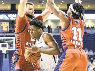  ?? MIKE CAUDILL/FREELANCE FILE ?? ODU’s Malik Curry, center, drives between Florida Atlantic’s Michael Forrest, right, and Aleksandar Zecevic last March. The Monarchs and Owls are scheduled to meet twice this weekend.