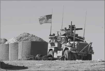  ?? The Associated Press ?? NEW INSTALLATI­ON: A U.S. soldier sits on an armored vehicle on Wednesday at a newly installed position near the tense front line between the U.S-backed Syrian Manbij Military Council and the Turkish-backed fighters in Manbij, north Syria. Even as...