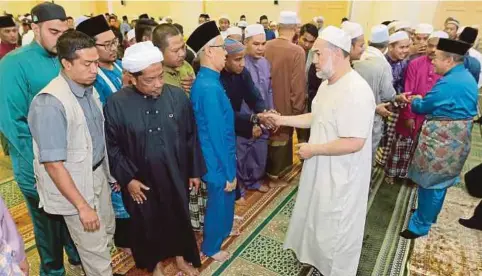  ?? (Foto Fathil Asri /BH] ?? Sultan Muhammad V bersalaman dengan jemaah selepas menunaikan solat sunat Aidiladha di Masjid Muhammadi, Kota Bharu. Yang turut hadir, Tengku Muhammad Fa-iz Petra.