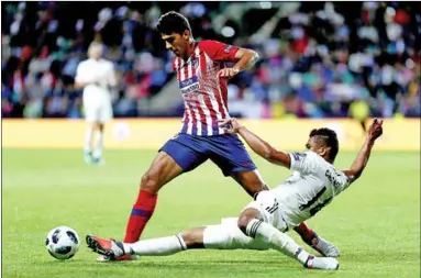  ??  ?? Casemiro van Real Madrid doet alles om het leder van richting te veranderen, terwijl Rodri van Atlético Madrid juist langs hem wil gaan. (Foto: UEFA)