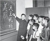  ?? TRIBUNE ARCHIVE ?? The Rev. John Mao, of St. Therese Chinese Catholic School, teaches “God Bless and Protect America” in Chinese to students in 1942.