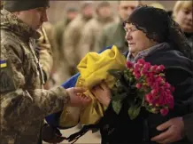  ?? ?? Tetiana Hurieieva, the mother of Volodymyr Hurieiev, a Ukrainian soldier killed in the Bakhmut area, receives the flag that draped his coffin, during the funeral in Boryspil, Ukraine, on Saturday. Pressure from Russian forces mounted Saturday on Ukrainians hunkered down in Bakhmut, as residents attempted to flee with help from troops who Western analysts say may be preparing to withdraw from the key eastern stronghold.