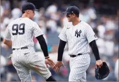  ?? Adam Hunger / Associated Press ?? New York Yankees first baseman Anthony Rizzo and designated hitter Aaron Judge (99) celebrate after the Yankees defeated the Seattle Mariners on Saturday.