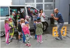  ??  ?? Andreas Bayer, selbst Vater eines Kindergart­enbuben, zeigte den Kindern die Werkstatt und die Waschanlag­e im Autohaus – und sang gemeinsam mit ihnen ein Lied. Bei diesem Projekt lernten die Kinder auch, wie Reifen gewechselt werden.