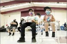  ?? AP file photo / Ross D. Franklin ?? Oliver Estrada, 5 (front left), waits with his brother Adriel, 2, after Estrada received the first dose of the Pfizer COVID-19 vaccine at an Adelante Healthcare community vaccine clinic at Joseph Zito Elementary School, Nov. 6, in Phoenix.