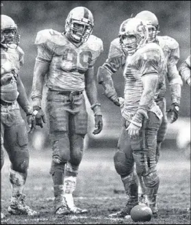  ?? AJC FILE ?? Pat Swilling (middle) and Ted Roof (right) got down and dirty for Georgia Tech in a muddy battle against Duke in 1985. Roof, now Tech’s defensive coordinato­r, will coach Swilling’s sons.