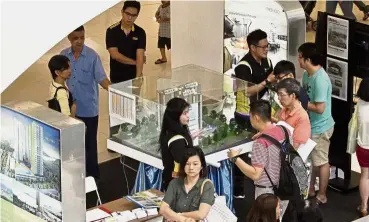  ??  ?? Visitors making enquiries at the fair in Queensbay Mall.