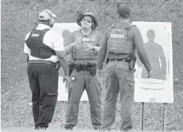  ?? JOE CAVARETTA/STAFF PHOTOGRAPH­ER ?? At the firing range in Markham Park in Sunrise, Broward County sheriff’s deputies train a member of the new armed guardians program.