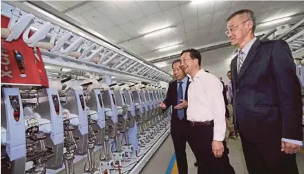  ?? AHMAD TAJUDDIN
PIC BY ZULKARNAIN ?? Dr Huang Huikang (centre) looking at textile production process at D&Y Textile (M) Sdn Bhd in Sedenak, Johor, yesterday. With him is D&Y Textile director, Steven Cheng (right).