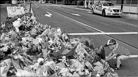  ??  ?? Een kind legt bloemen op de herdenking­splaats van de aanslag. (Foto: NU)